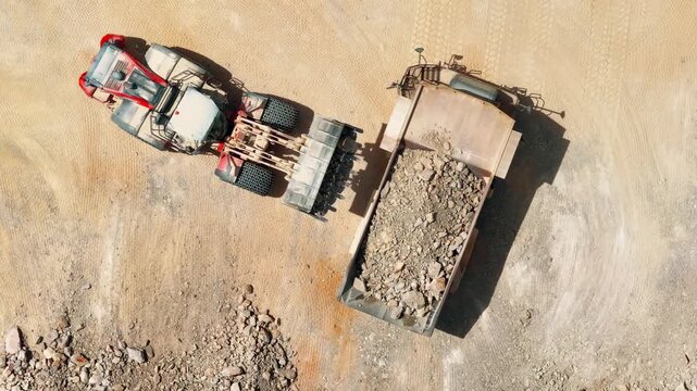 Heavy machinery transports aggregate from quarry to processing facility for cement production operations