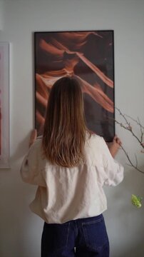 Woman from behind hanging framed wall art