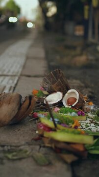 Balinese canang sari street offering with coconut egg and flowers