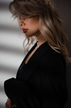 Elegant woman in black blazer with blonde hair and red lipstick