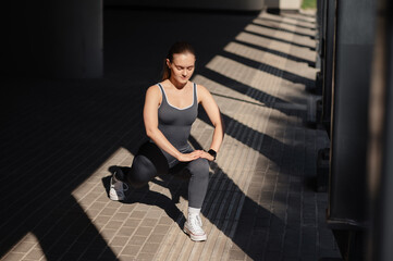 Naklejka premium Woman performing a lunge exercise outdoors with dramatic shadows and light patterns