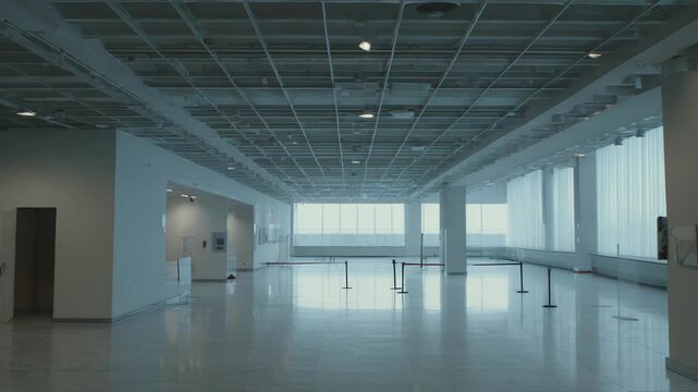 Modern art museum hall featuring a wide, open space with high ceilings, polished floors, and large windows, ready for a new exhibition, conveying spaciousness and potential