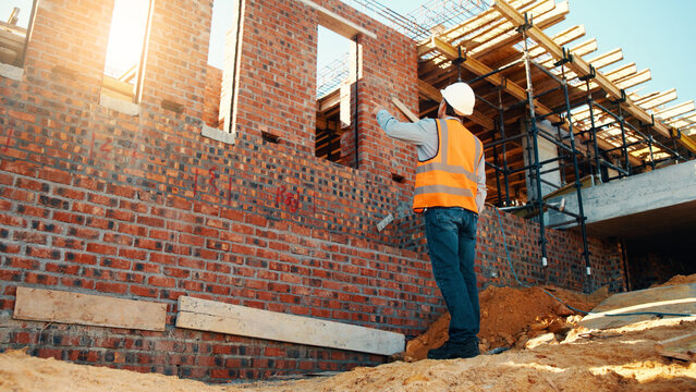 Construction, point and man with building inspection for masonry safety, progress and compliance. Back, foreman or monitor development for defect management, quality control and outdoor on low angle