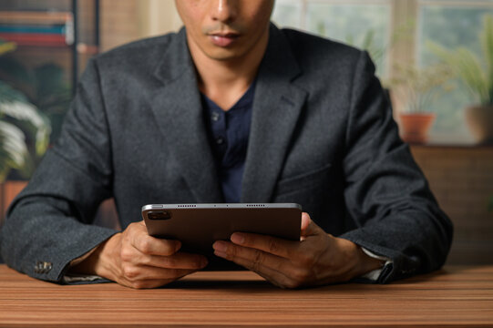 Businessman Using Tablet in Modern Office Setting with Plants