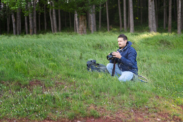 Fototapeta premium Mid adult hiker with camera take pictures while hiking in beautiful mountain scenery, relaxed and happy to be outdoors and enjoying his hobby