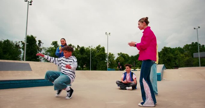 Talented teenager breakdancing for his friends at a skatepark