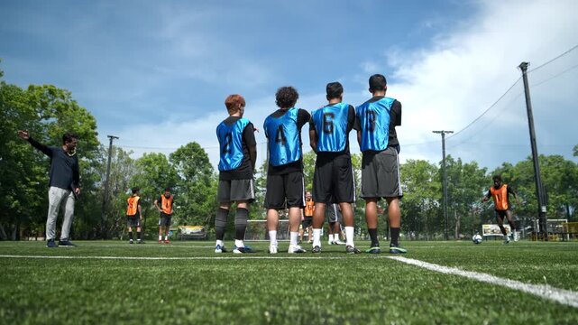 Soccer players jumped together during training to practice defensive tactics by forming a wall to protect the goal from free kicks. This demonstrates teamwork and athletic performance on the field