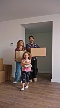 Happy family carrying boxes into their new home