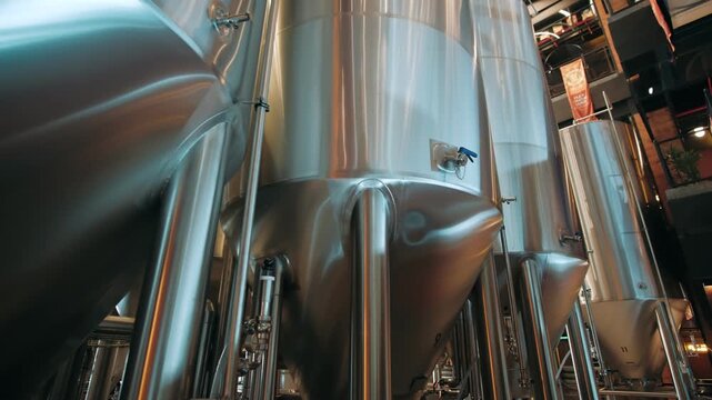 Modern craft beer brewery showcasing large stainless steel fermentation tanks for beverage production and maturation process