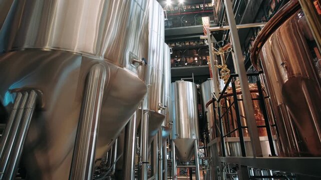 Steel fermenting tanks and copper vats in a modern craft beer brewery. Industrial beer production technology
