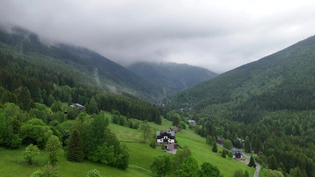 Aerial view of mountain valley with spruce forest and village in Krkono&scaron;e Mountains Czech Republic in summer