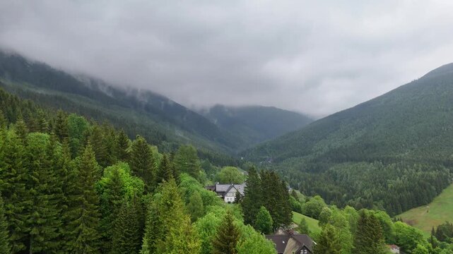 Aerial view of mountain valley with spruce forest and village in Krkono&scaron;e Mountains Czech Republic in summer