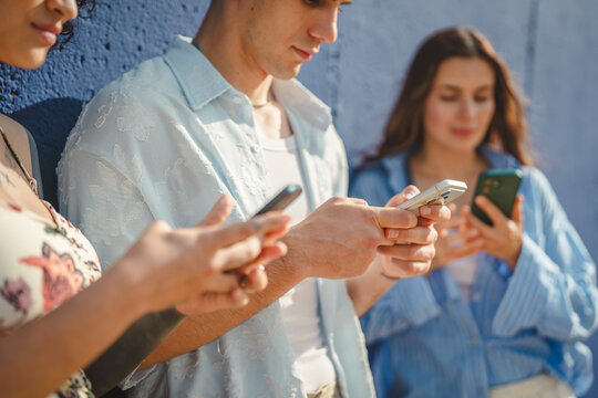 Young people using smart phones ignoring each other outdoors