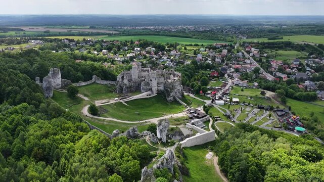 Aerial drone view of Ogrodzieniec and Podzamcze in southern Poland during spring, showcasing historic market square, village landscape, ponds and the Jura countryside scenery