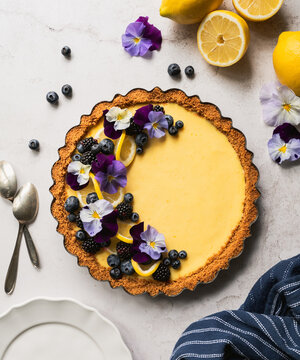 Beautiful lemon tart with fresh berries and flowers