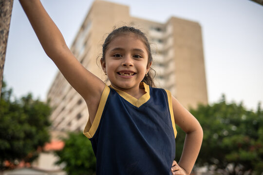 Confident little basketball player smiling outdoors
