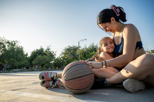 Mother and daughter sharing a warm hug after basketball practice