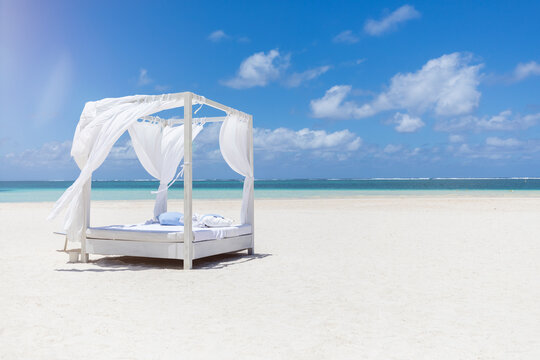 Mauritius, Belle Mare, white beach bed at beach, blue sky and clouds