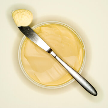 Margarine curl lying on back of a knife, elevated view