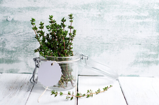 Fresh thyme in a preserving jar on wood