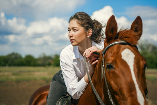 Woman on horse, looking away, sunny day, outdoor