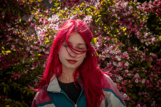 Young woman with bright red hair and eyes closed