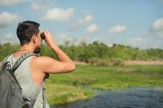 Man on a hike using binoculars in nature with copy space