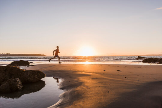 France, Crozon peninsula, jogger on the beach at sunset