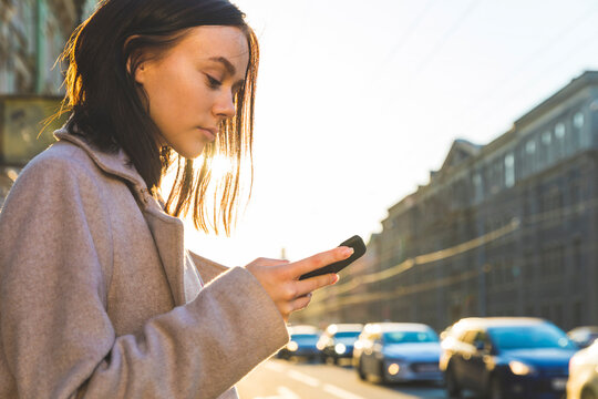 Russia, St. Petersburg, young woman using smartphone in the city