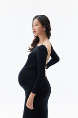 Fototapeta premium Elegant pregnant woman in black dress side profile studio portrait