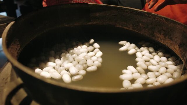 Silk cocoons boiling in hot water in a traditional vietnam factory for sericulture production