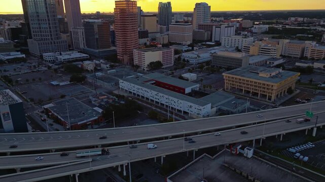 Aerial view of tampa cityscape at sunset with highway traffic and modern buildings under golden sky.