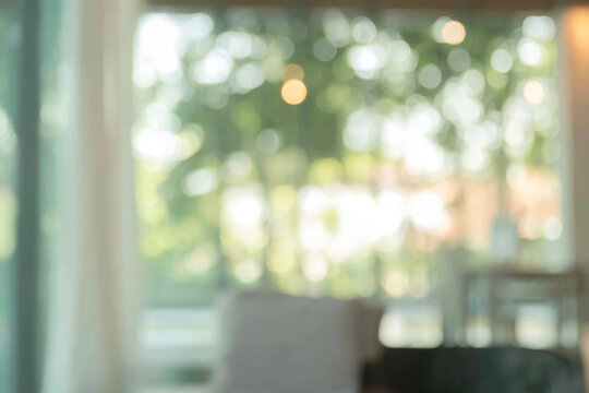 Soft natural green bokeh background with warm light, blurred outdoor foliage through a window.