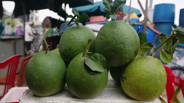 Green pomelo citrus fruits for sale at a vibrant vietnamese street market in southeast asia, Ha noi