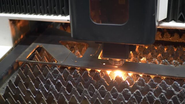 Laser beam creates bright sparks during sheet metal cut. Metalwork precision, high power energy and automated industry technology