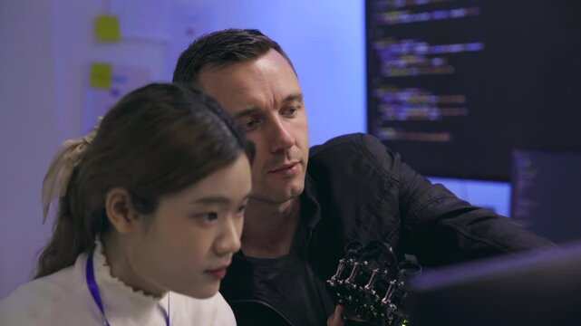 Tech developers collaborating on a robotic device in a lab