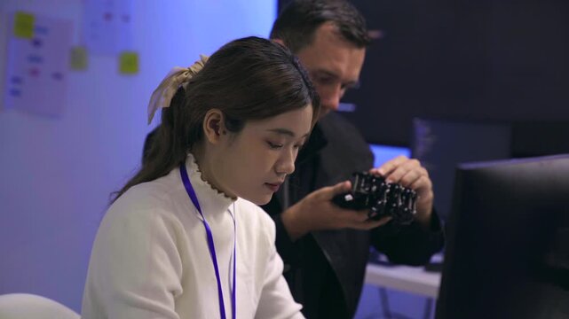 Tech developers collaborating on a robotic device in a lab
