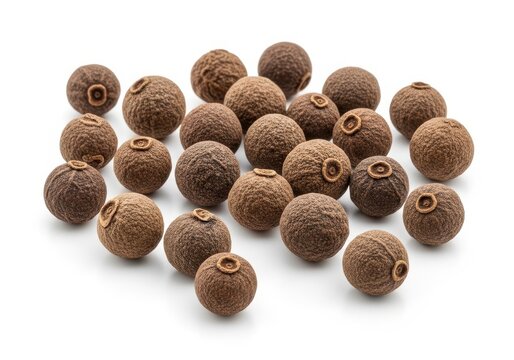 Group of whole allspice berries scattered on a clean solid white background