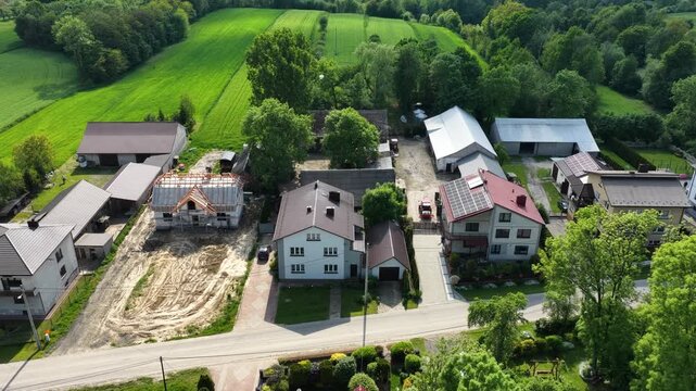 Aerial drone view of Chlina village in Silesian Voivodeship, Poland, featuring historic church, agricultural fields and rural countryside landscape during a sunny spring season. Church near the lake