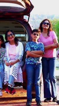 Indian family sitting in car dicky outdoors ready to go for picnic enjoying fun moments, grandparents, parents, and kids relaxing together, sharing laughter and bonding during a joyful outdoor break