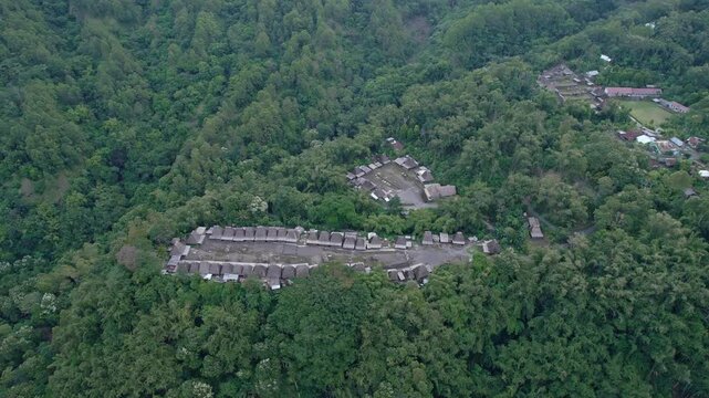 Aerial view of Bena Traditional Village with its iconic thatched roofs surrounded by lush tropical forest and green hills Kecamatan Jerebuu, Nusa Tenggara Timur, Indonesia.