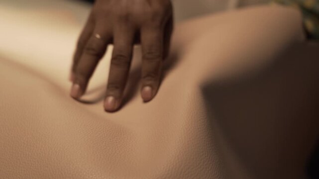 Close-up of hands inspecting a leather sheet for designing and crafting a lifestyle product.