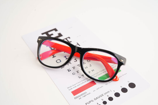 Glasses on eye testing exam chart to check eyesight accuracy of reading.