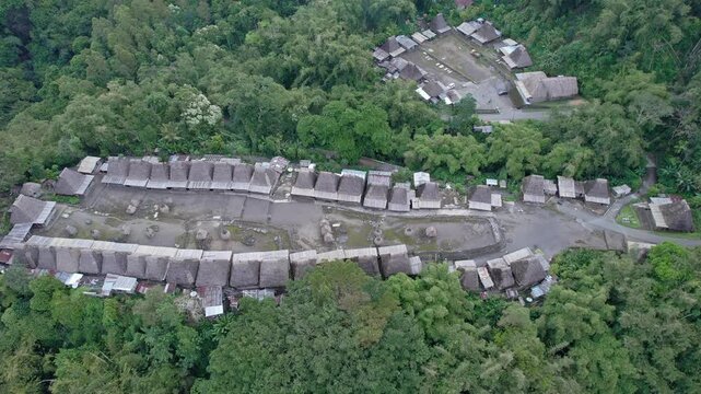 Aerial view of Bena Traditional Village with its iconic thatched roof houses nestled in the lush green forest of Kecamatan Jerebuu, Nusa Tenggara Timur, Indonesia.
