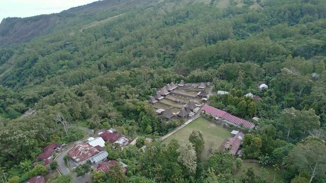 Aerial view of Bena Traditional Village with iconic thatched roofs nestled in a lush valley surrounded by dense forest Kecamatan Jerebuu, Nusa Tenggara Timur, Indonesia.