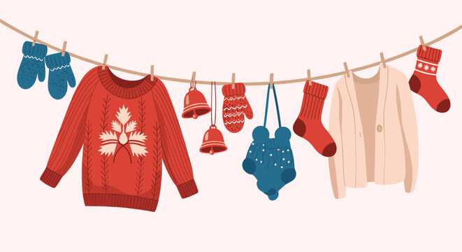 Assorted winter clothes including a red sweater with leaf pattern hat mittens and socks hanging on a clothesline for festive laundry concept.