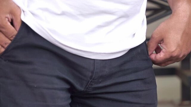 Empty pocket gesture by a man, illustrating money problems,