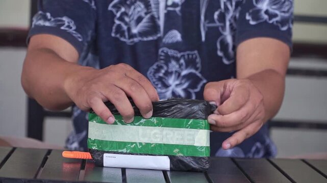 Hands unboxing a delivery package, e-commerce shipping and online shopping concept with parcel opening and product reveal on table.