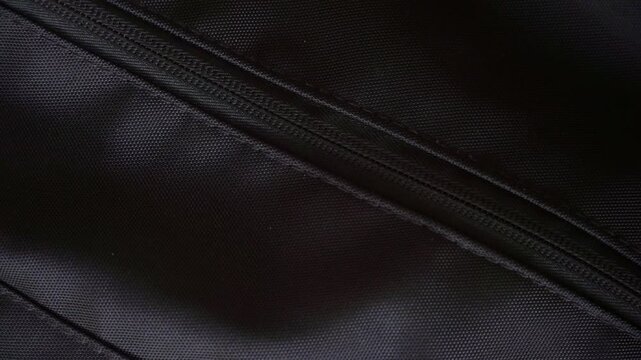 a hand unzipping a bag and taking out a smartphone, highlighting daily lifestyle, technology, and personal belongings.