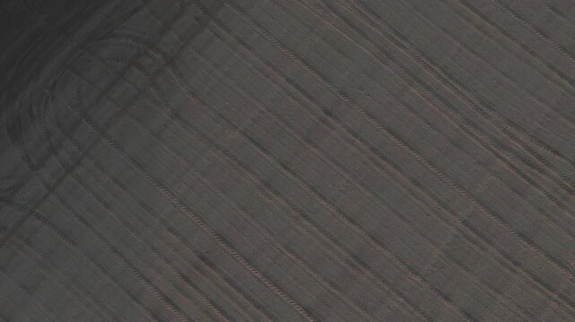 Cultivated farmland in the Po Valley, Italy, revealing plowed agricultural soil textures and geometric field patterns across alluvial lowlands, top down drone orbit shot.